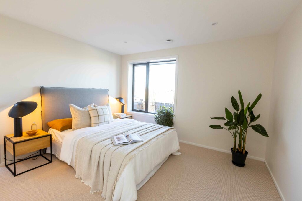 Neutral bedroom with plant in corner