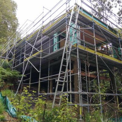 Home under construction surrounded by scaffolding and native bush