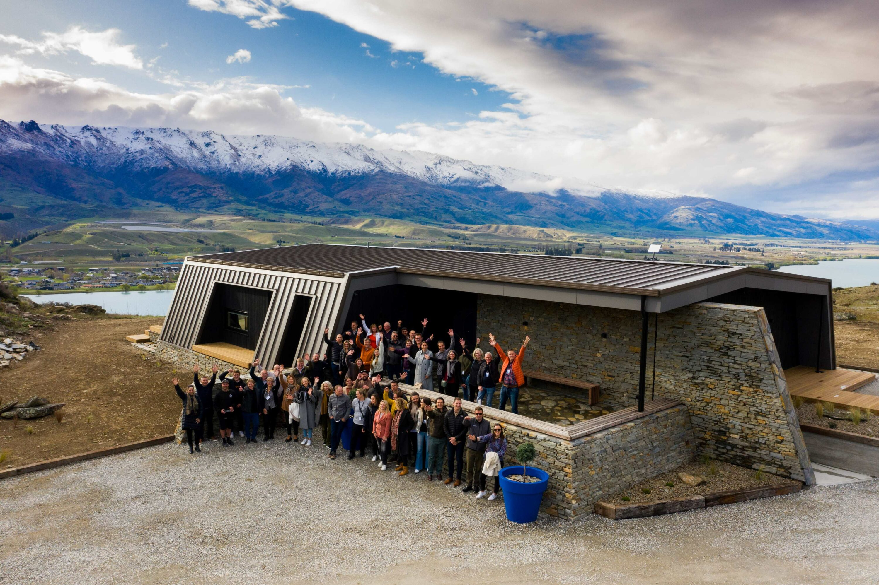 eHaus team outside modern new build with mountains in the background